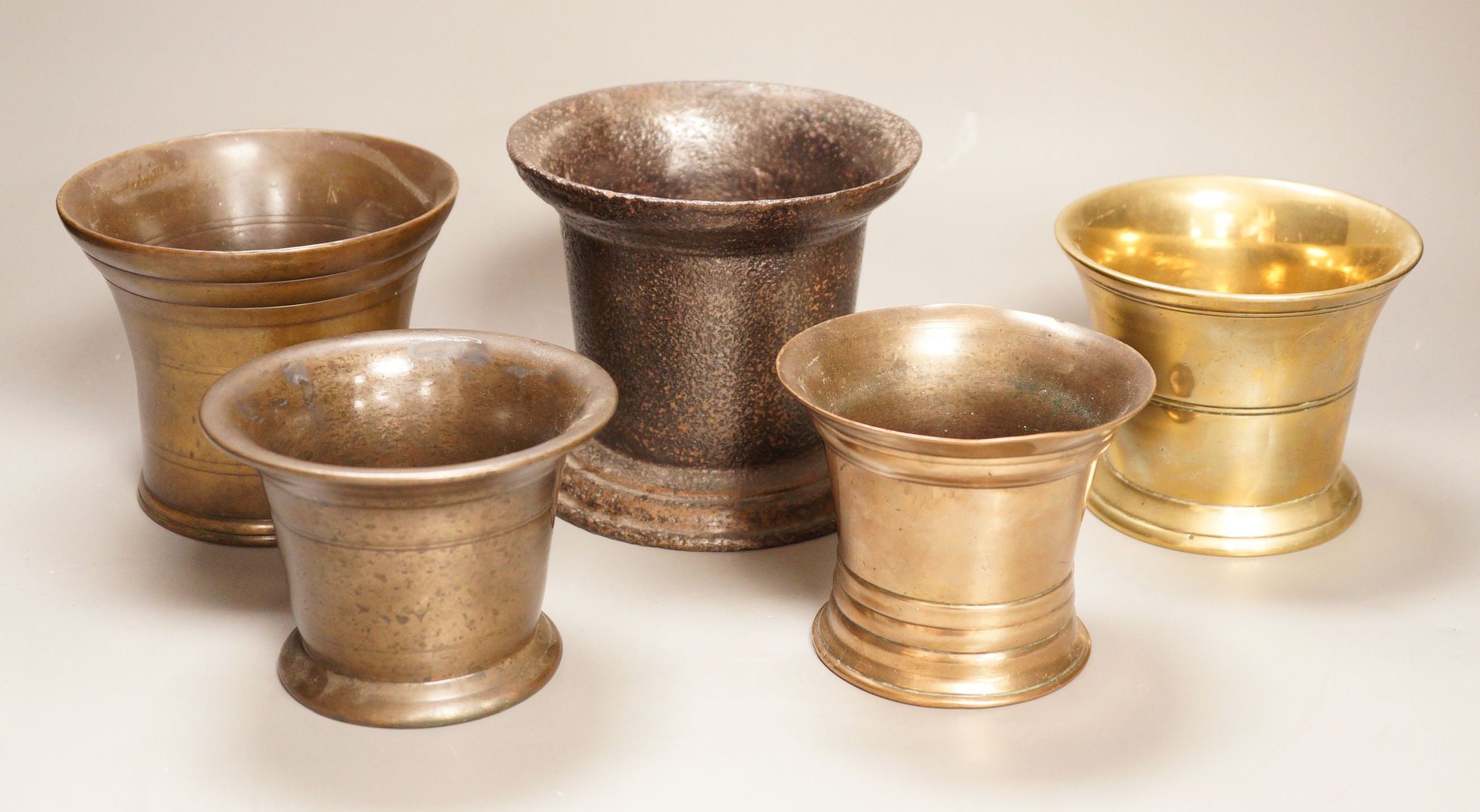 A group of four various bronze mortars and a similar cast-iron example, Largest 13 cm high